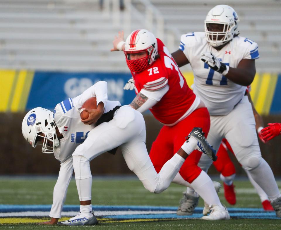 Dover quarterback Nahseem Cosme (left) is pursued by Smyrna's Caleb Blane (72) as Dover offensive lineman Jason Hoskins joins the play in the second quarter of the DIAA Class 3A championship at Delaware Stadium, Saturday, Dec. 10, 2022.