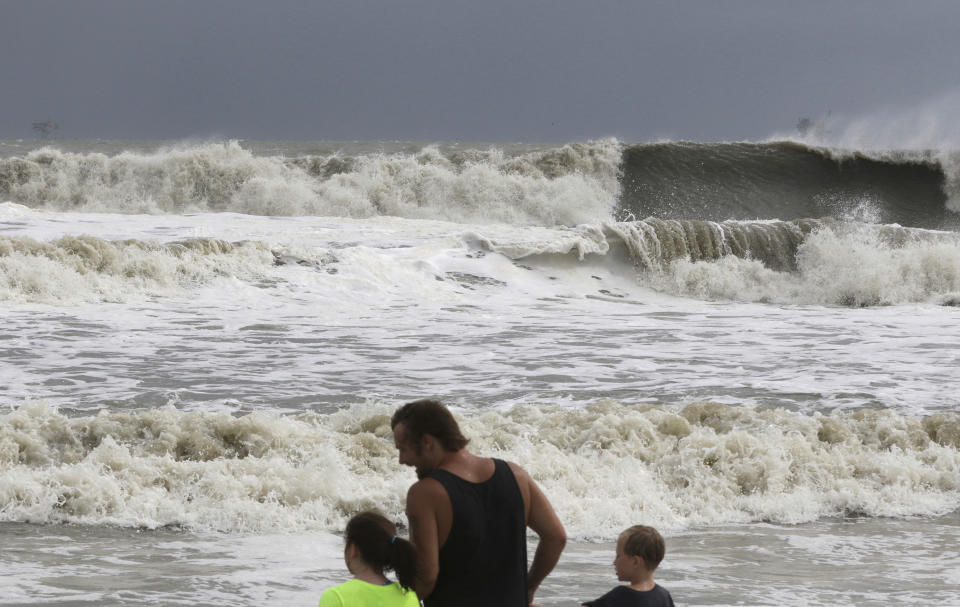Laura Cunningham, 10,left, Hunter Shows, center, and Brandon Perry, 10, right, watch the waves crash from Tropical Storm Gordon on Tuesday, Sept. 4, 2018 in Dauphin Island, Ala. (AP Photo/Dan Anderson)
