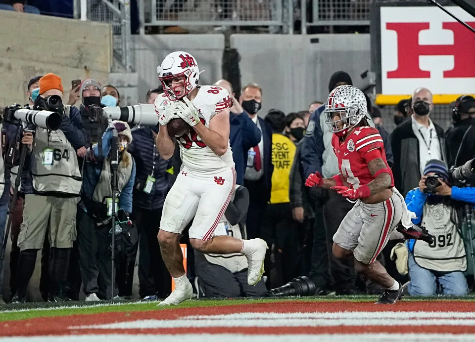 Utah Utes tight end Dalton Kincaid (86) catches a touchdown pass behind Ohio State Buckeyes safety Ronnie Hickman (14) during the fourth quarter of the Rose Bowl in Pasadena, Calif. on Jan. 1, 2022.
