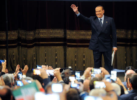 FILE PHOTO: Forza Italia party leader Silvio Berlusconi waves to his supporters during a rally for the regional election in Palermo, Italy, November 1, 2017. REUTERS/Guglielmo Mangiapane/File Photo