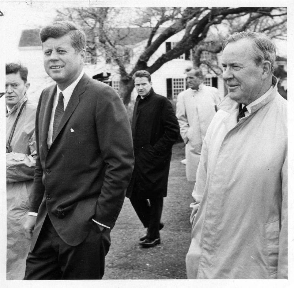 President John F. Kennedy heads to a press conference behind his house on Irving Avenue in Hyannisport. A mortgage note from 1957 between JFK and his father for the purchase of the house is up for auction.