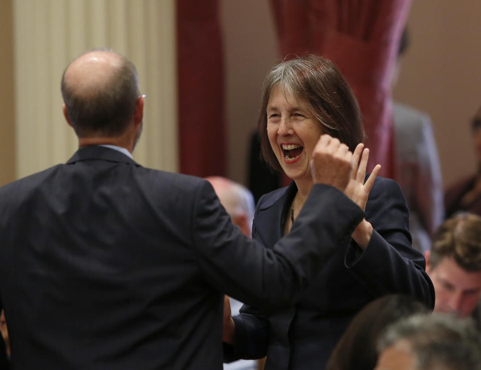 Sen. Nancy Skinner, D-Berkeley, celebrates with Sen. Steven Glazer, D-Orinda, after her measure to let athletes at California colleges hire agents and sign endorsement deals was approved by the Senate in Sacramento, Calif., Wednesday, Sept. 11, 2019. The bill now goes to Gov. Gavin Newsom, who has not said whether he will sign it. But the NCAA Board Of Governors is already urging him not to, sending him a letter Wednesday saying the bill "would erase the critical distinction between college and professional athletics" and would have drastic consequences for California's colleges and universities. (AP Photo/Rich Pedroncelli)