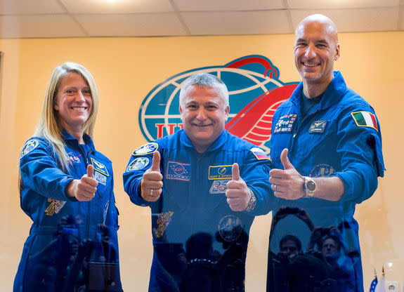 Expedition 36/37 Soyuz Commander Fyodor Yurchikhin of the Russian Federal Space Agency (Roscosmos), center, Flight Engineers; Karen Nyberg of NASA, left, and Luca Parmitano of the European Space Agency, give a thumbs up after the crew's press c