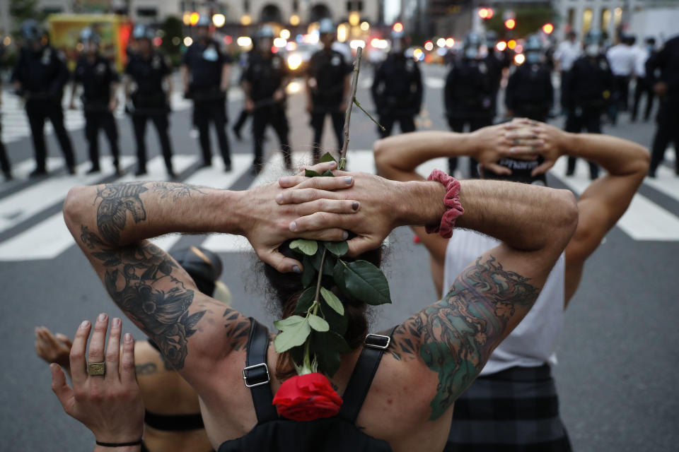 FILE - Protesters kneel in front of New York City Police Department officers before being arrested for violating curfew beside the iconic Plaza Hotel on 59th Street, Wednesday, June 3, 2020, in New York. Protests continued following the death of George Floyd, who died after being restrained by Minneapolis police officers on May 25. (AP Photo/John Minchillo, File)