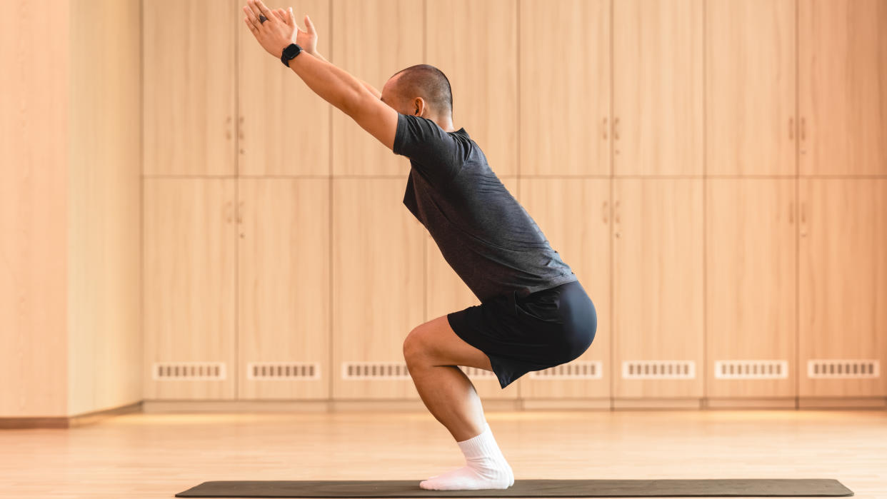  Man practicing yoga in a studio. 