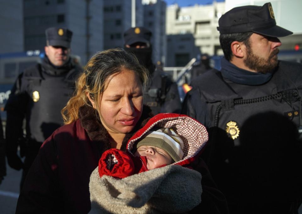 Paredes holds her one-month-old son Dilan in front of riot policemen after her family was evicted from their apartment in Madrid