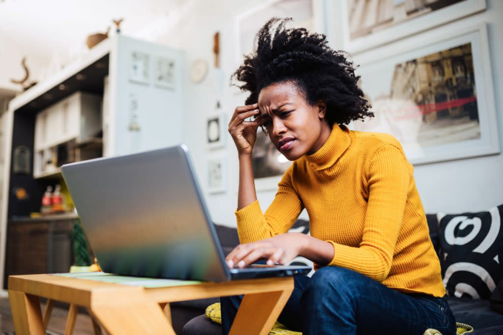 A woman looks confused as she looks at her laptop.