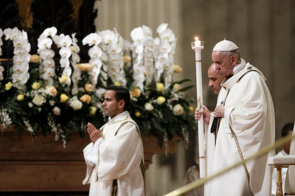 Pope Francis holds a candle as he presides over a solemn Easter vigil ceremony in St. Peter's Basilica at the Vatican, Saturday, April 21, 2019. (AP Photo/Gregorio Borgia)