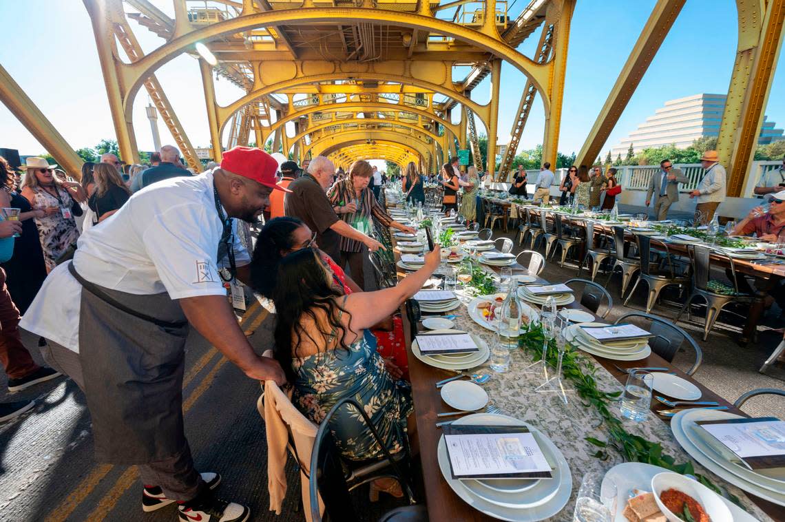 Chef Cecil Rhodes II of Nash & Proper takes for a photo with his wife Veronica Rhodes and her friend Darlene Osias 
at the Farm-to-Fork Festival’s Tower Bridge Dinner on Sunday.