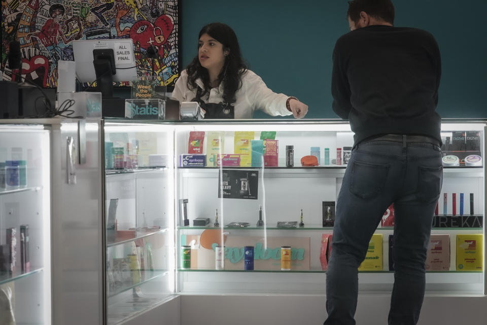 Alex Silecchia, left, a marijuana "budtender," also known as a sales associate, serves a customer at States Cannabis Company dispensary, Friday, Sept. 29, 2023, in New York. New York is set to dramatically expand its legal weed market and issue more than 1,000 new licenses starting early next year, with a priority on retail. (AP Photo/Bebeto Matthews)