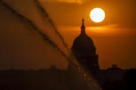 Sprinklers shoot jets of water along the National Mall as the sun rises behind the Capitol in Washington, Wednesday, Sept. 15, 2021. (AP Photo/J. Scott Applewhite)