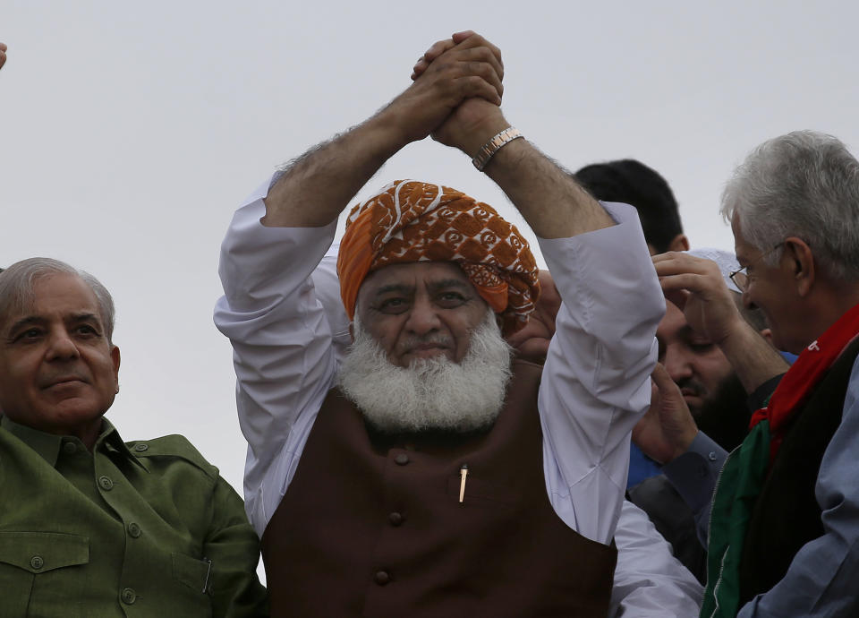 Radical cleric and leader of Islamist party 'Jamiat Ulema-e-Islam' Maulana Fazlur Rehman, center, waves to his supporters during an anti-government march, in Islamabad, Pakistan, Friday, Nov. 1, 2019. Thousands of members of a radical Islamist party have camped out in Pakistan's capital, demanding the resignation of Prime Minister Imran Khan over economic hardships. (AP Photo/Anjum Naveed)