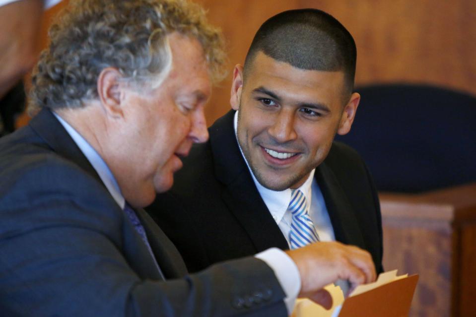 REFILE - CORRECTING NAME OF LAWYER Former NFL player Aaron Hernandez (R) smiles at his lawyer, Michael Fee, during a hearing at Bristol County Superior Court in Fall River, Massachusetts July 9, 2014. The hearing was held to decide on Hernandez' lawyers' request for his medical and combine draft records from the New England Patriots, that might be relevant to him as he prepares for two trials where he will face charges of murdering three men. REUTERS/Dominick Reuter (UNITED STATES - Tags: CRIME LAW SPORT FOOTBALL SOCIETY)