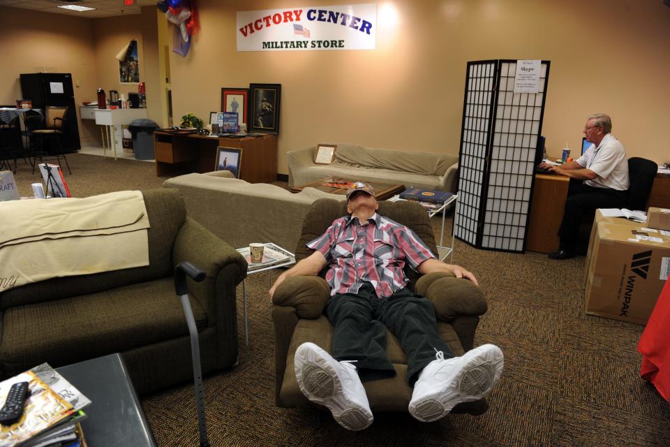 The back area of The Victory Center Military Store in Vero Beach is known as the "R&R Bunker." It is a place where veterans can go to spend time while at the mall, meet other veterans, visit with the volunteers at the store, or get information about veteran services available in the area. Al, who preferred to only give his first name, catches a nap on Jan. 9, 2012, while visiting the "R&R Bunker." Retired U.S. Air Force Colonel Martin Zickert (right), works in the office area where a Skype connection exists for familes to communicate with their other family members in the military.