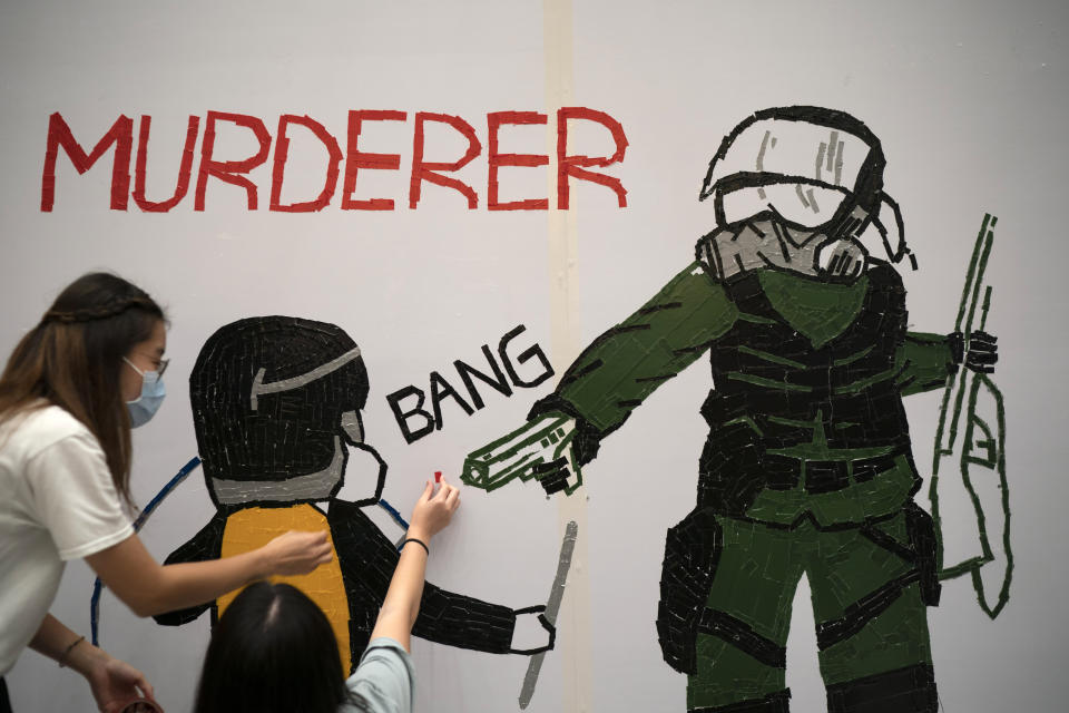 Protestors make a mural depicting a teenage demonstrator shot at close range in the chest by a police officer, in Hong Kong, Wednesday, Oct. 2, 2019. The shooting Tuesday during widespread anti-government demonstrations on China's National Day was a fearsome escalation in Hong Kong's protest violence. The 18-year-old is the first known victim of police gunfire since the protests began in June. He was hospitalized and his condition was described by the government as stable on Wednesday. (AP Photo/Felipe Dana)