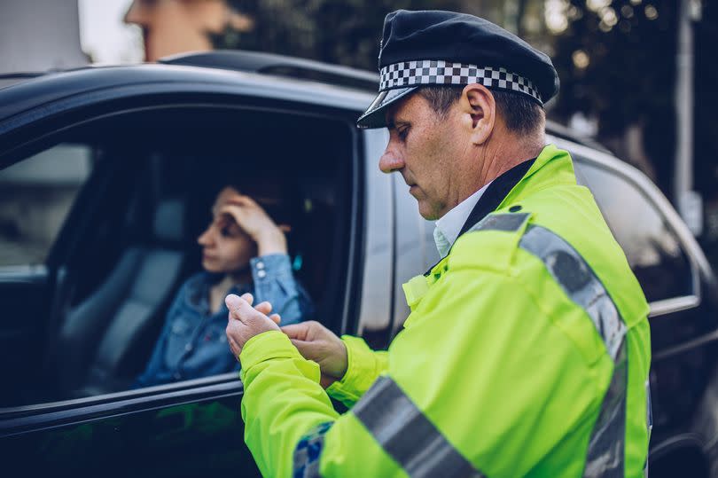 Young woman pulled over by police officer on the road.