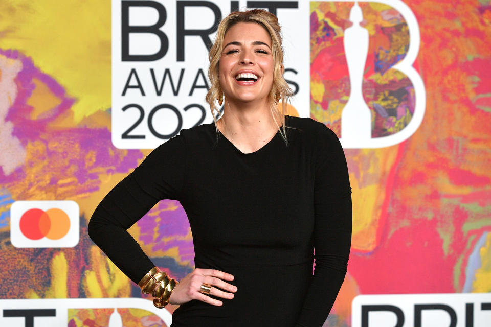 Gemma Atkinson poses in a black dress with her hand on her hips