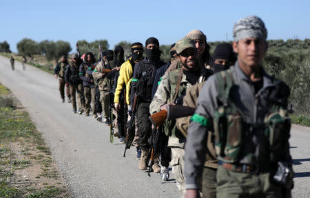 Turkish-backed Free Syrian Army fighters walk together after advancing north of Afrin, Syria March 17, 2018. REUTERS/Khalil Ashawi