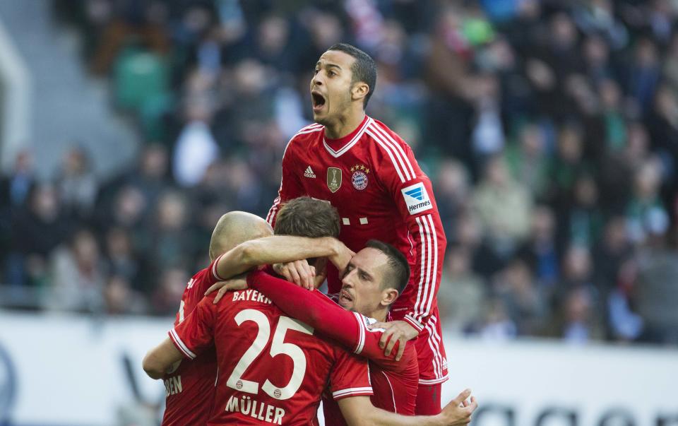 Bayern's Thiago Alcantara of Spain, top, Bayern's Arjen Robben of the Netherlands, Bayern's Thomas Mueller, and Bayern's Franck Ribery of France, bottom from left, celebrate after Mueller scored his side's 2nd goal during the German Bundesliga soccer match between VfL Wolfsburg and Bayern Munich in Wolfsburg, Germany, Saturday, March 8, 2014. (AP Photo/Gero Breloer) 