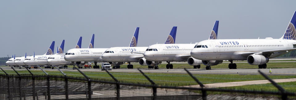 FILE - In this March 25, 2020 file photo, United Airlines planes are parked at George Bush Intercontinental Airport in Houston. United Airlines will send layoff warnings to 36,000 employees - nearly half its U.S. staff - in the clearest signal yet of how deeply the virus outbreak is hurting the airline industry. United officials said Wednesday, July 8 that they still hope to limit the number of layoffs by offering early retirement, but they have to send notices this month to comply with a law requiring that workers get 60 days' notice ahead of mass job cuts. (AP Photo/David J. Phillip, File)