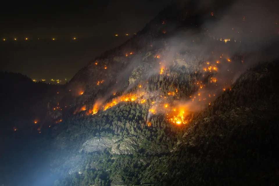 General view of a wildfire on the flank of a mountain in Bitsch near Brig, Switzerland, July 18, 2023. Picture taken with a long exposure. REUTERS/Denis Balibouse