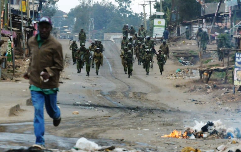 A man runs away from Kenyan security forces patrolling in a Nairobi slum following overnight demonstrations by supporters of opposition leader Raila Odinga who are demanding that President Uhuru Kenyatta's re-election be overturned