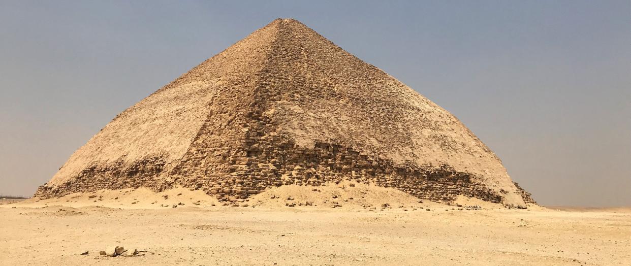 The Bent Pyramid is an ancient Egyptian pyramid located at the royal necropolis of Dahshur, approximately 40 kilometres south of Cairo, built under the Old Kingdom Pharaoh Sneferu (c. 2600 BC).