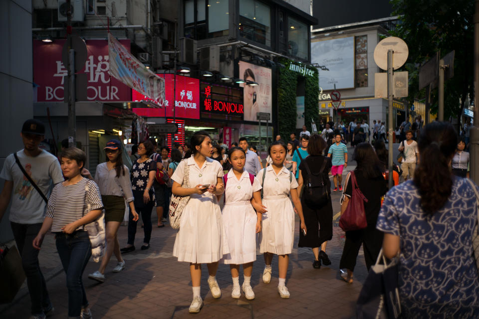 School students walk down a street in Hong Kong on July 4, 2016.