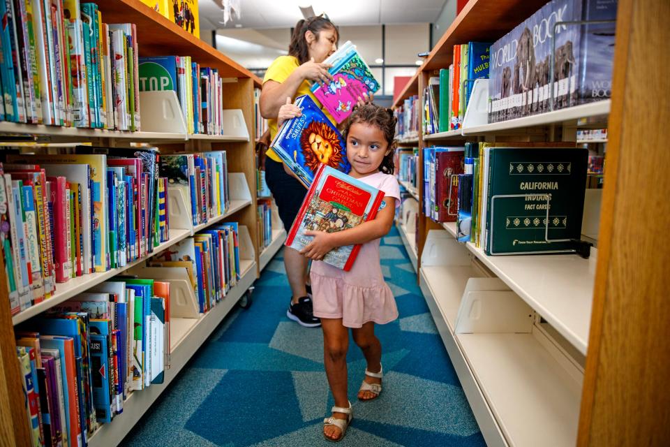 Mayra Juarez helps her daughter Leah Noriego, 5, of Coachella pick out books to read at the Rancho Mirage Library and Observatory in Rancho Mirage, Calif., on Monday, June 3, 2024. The annual, open to all ages, Summer Reading Club at Rancho Mirage Library and Observatory begins June 10, 2024, and wraps up on August 2nd at the library in Rancho Mirage.