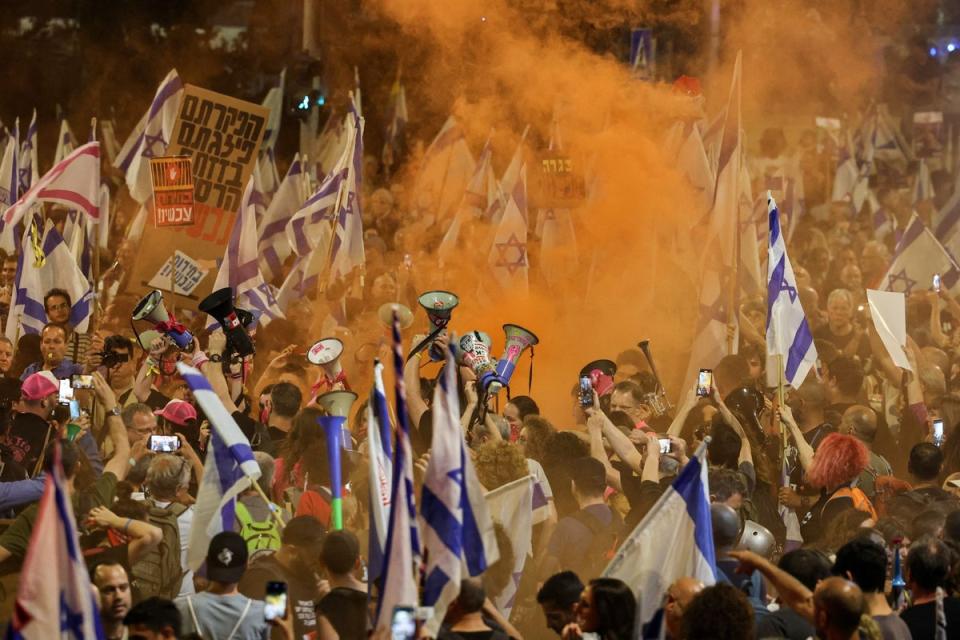 Demonstrators hold up flags and flares (AFP via Getty Images)