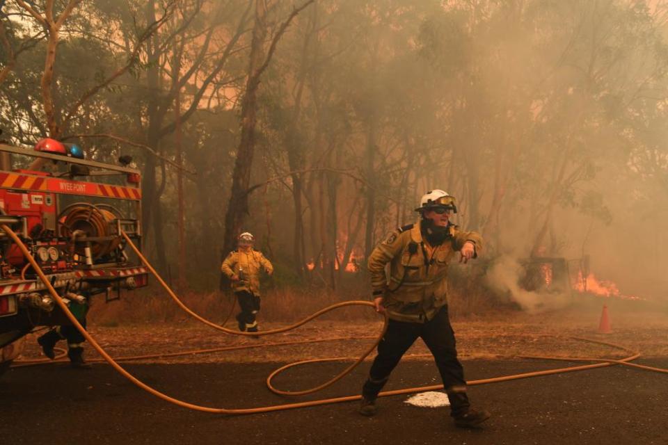 RFS firefighters prepare to fight fire-spotting at the Three Mile Fire on the NSW Central Coast on Tuesday.