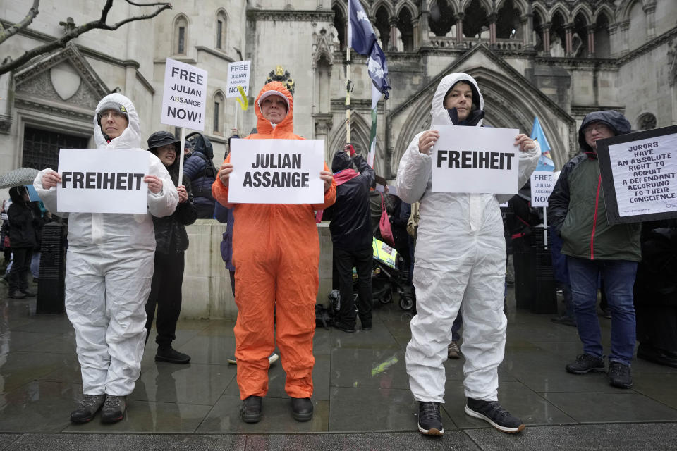 Protesters stand outside the Royal Courts of Justice in London, Wednesday, Feb. 21, 2024. Julian Assange's lawyers are on their final U.K. legal challenge to stop the WikiLeaks founder from being sent to the United States to face spying charges. The 52-year-old has been fighting extradition for more than a decade, including seven years in self-exile in the Ecuadorian Embassy in London and the last five years in a high-security prison. (AP Photo/Kin Cheung)