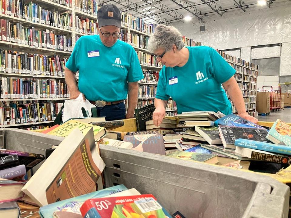 Tim and Sheree Slagle, of Nebraska, sift through free books after touring the Thriftbooks warehouse in Phoenix on Oct. 20, 2023.