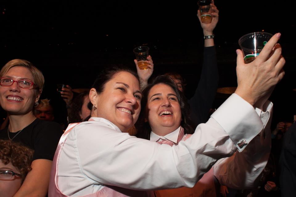 SEATTLE, WA - DECEMBER 9: Newlyweds Cathi Korth and Kathryn Antonetti raise a glass during a ceremonial toast at "A Wedding Reception for All," which was attended by hundreds and held at the Paramount Theatre on December 9, 2012 in Seattle, Washington. They have been together for 25 years, 11 months, and 13 days. Today is the first day that same-sex couples can legally wed in Washington state. (Photo by David Ryder/Getty Images)