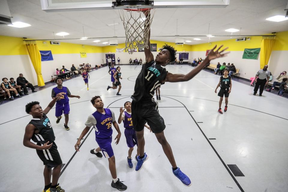 Aijalon Williams towers over other middle schoolers as he dunks during a midseason game.