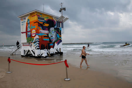 A beachgoer walks near a decorated lifeguard tower which was renovated into a luxury hotel suite as part of an international online competition, at Frishman Beach in Tel Aviv, Israel March 14, 2017. REUTERS/Baz Ratner