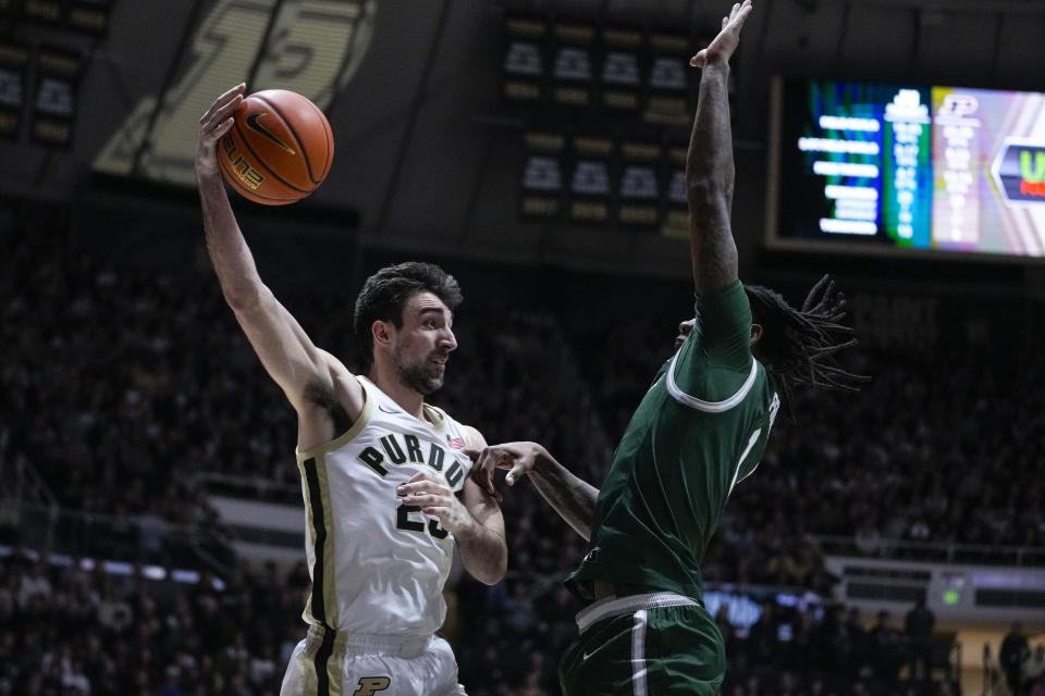 Purdue guard Ethan Morton (25) passes over Jacksonville forward DeeJuan Pruitt (1) during the second half of an NCAA college basketball game in West Lafayette, Ind., Thursday, Dec. 21, 2023. (AP Photo/Michael Conroy)