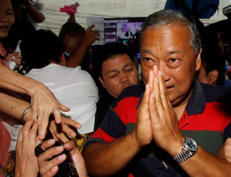 Democrat Party candidate and incumbent governor Sukhumbhand Paribatra gestures as he arrives at the Democrat Party headquarters in Bangkok March 3, 2013. REUTERS/Chaiwat Subprasom/File Photo