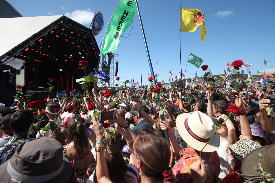 The crowd are handed out roses during a duet between Kylie Minogue with guest Nick Cave on the Pyramid Stage on the fifth day of the Glastonbury Festival at Worthy Farm in Somerset. (Photo by Yui Mok/PA Images via Getty Images)