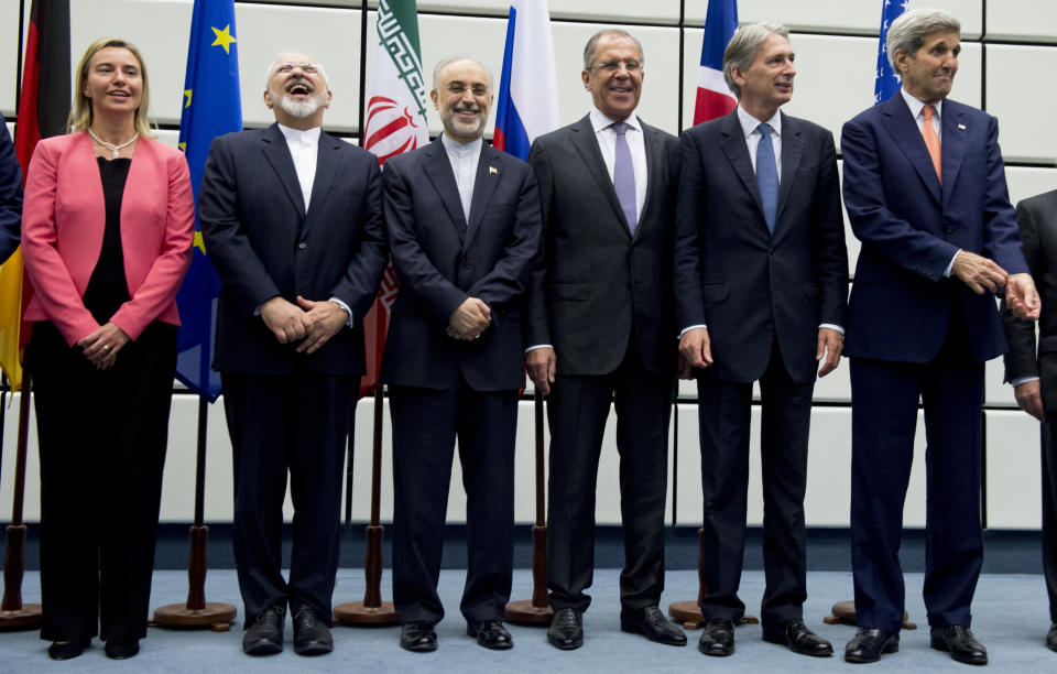 FILE - In this July 14, 2015 file photo, from left to right: European Union High Representative Federica Mogherini, Iranian Foreign Minister Mohammad Javad Zarif, Head of the Iranian Atomic Energy Organization Ali Akbar Salehi, Russian Foreign Minister Sergey Lavrov, British Foreign Secretary Philip Hammond and U.S. Secretary of State John Kerry pose for a group picture at the United Nations building in Vienna, Austria. Iran threatened Wednesday, May 8, 2019, to resume higher enrichment of uranium in 60 days if world powers fail to negotiate new terms for its 2015 nuclear deal, an agreement that capped over a decade of hostility between Tehran and the West over its atomic program. (Joe Klamar/Pool Photo via AP, File)