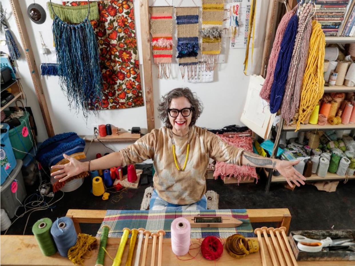 Janelle Pietrzak sits at a loom in her studio.