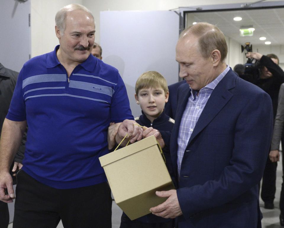 Russian President Vladimir Putin (R) speaks with his Belarussian counterpart Alexander Lukashenko (L) and Lukashenko's son Nikolai (C) before a friendly ice hockey match in the Bolshoi Ice Palace near Sochi January 4, 2014. REUTERS/Alexei Nikolskiy/RIA Novosti/Kremlin (RUSSIA - Tags: POLITICS SPORT OLYMPICS) ATTENTION EDITORS - THIS IMAGE HAS BEEN SUPPLIED BY A THIRD PARTY. IT IS DISTRIBUTED, EXACTLY AS RECEIVED BY REUTERS, AS A SERVICE TO CLIENTS