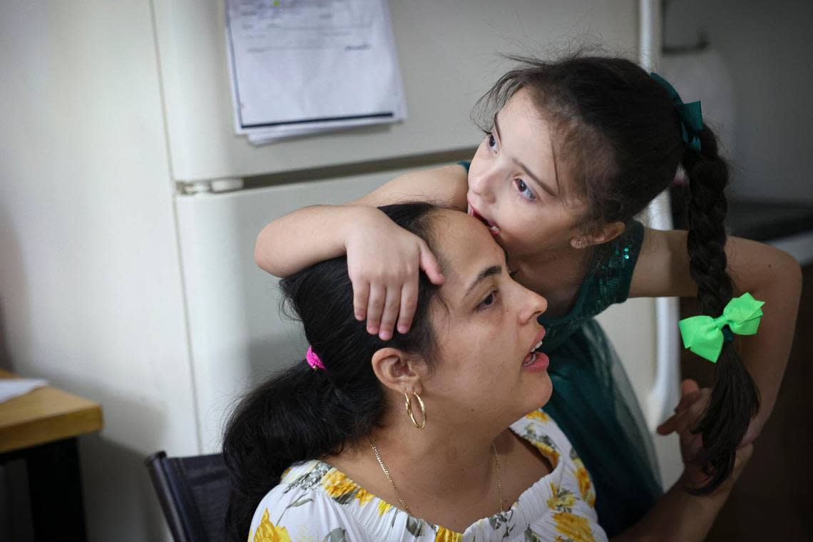 Katherin Leyva, 5, kisses her mother, Beatriz Perez, in the family’s apartment on Thursday, Dec. 1, 2022, in Hialeah. Leyva is diagnosed with Austism Spectrum Disorder. The family lost the majority of their possessions in a fire.