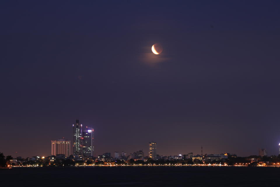 The eclipsed moon glows in the sky in Hanoi, Vietnam, Wednesday, May 26, 2021. The first total lunar eclipse in more than two years coincides with a supermoon, creates a phenomenon called a super "blood" moon. (AP Photo/ Hau Dinh)