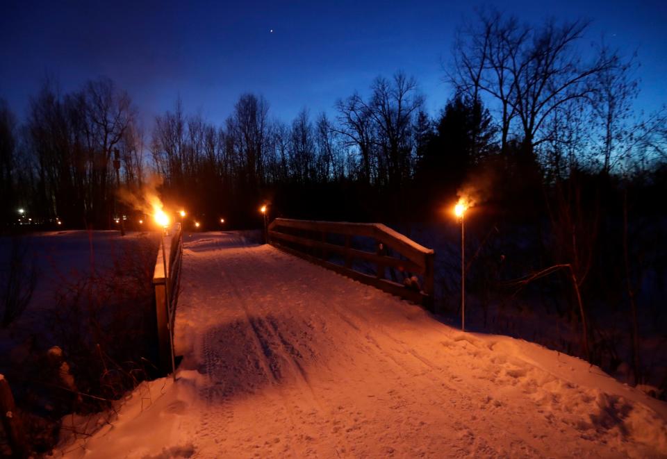 A trail at L.H. Barkhausen Waterfowl Preserve is illuminated for a candlelit hiking event on Jan. 7, 2022, in Suamico, Wis.