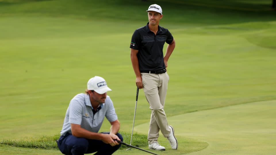 Pereira (right) waits as a competitor lines up a putt. - Mike Mulholland/Getty Images