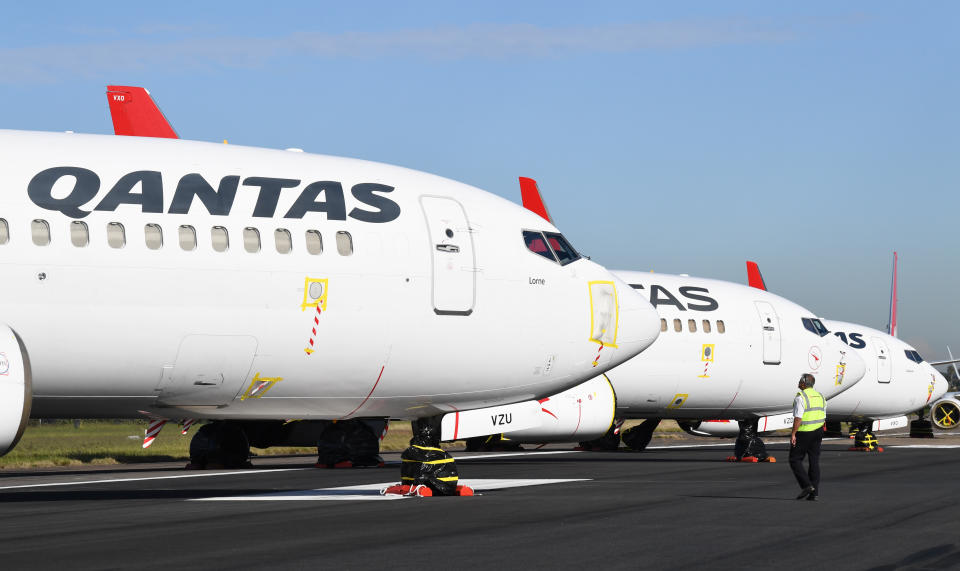 SYDNEY, AUSTRALIA - MAY 20: Licensed maintenance engineers for Qantas check on their Boeing 737-800 aircraft parked on the east-west runway at Sydney's International airport on May 20, 2020 in Sydney, Australia. Nine Qantas aircraft are currently in "active storage" on the runway, in a state of readiness for flight and can be prepared within 24 hours notice should they be required as conditions change. Sydney Airport has temporarily shut the east west runway to make space to store aircraft grounded due to the global COVID-19 pandemic. With non-essential travel currently banned in Australia, Qantas and Virgin Australia have grounded most of their fleets, operating a limited number of domestic and international flights. (Photo by James D. Morgan/Getty Images)