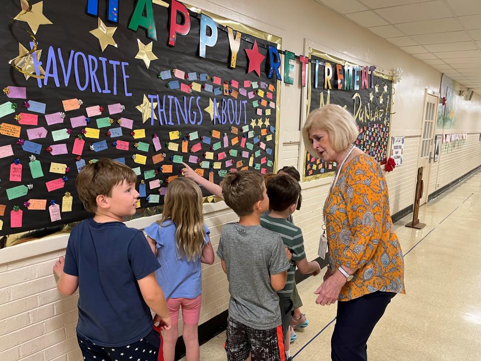 Retiring Bearden Elementary principal Susan Dunlap talks with some first graders on May 9, 2023, in front of a bulletin board with notes from students wishing her well in her retirement and thanking her for her service.