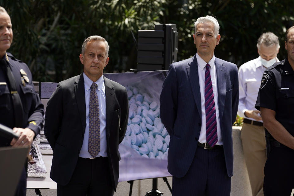 Agents stand in front of images of illegal drugs outside the Edward R. Roybal Federal Building, Thursday, May 13, 2021, in Los Angeles. Federal authorities say they have arrested at least 10 suspected drug dealers accused of selling fentanyl and other opioids that led to overdose deaths. (AP Photo/Marcio Jose Sanchez)