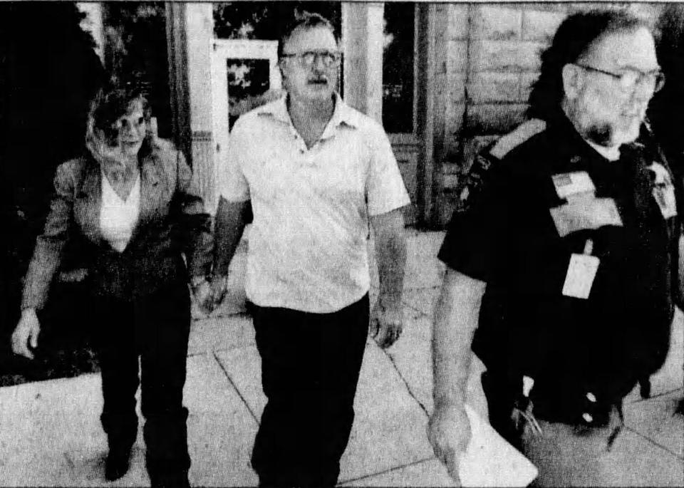 Pamela Polejewski, left and her partner Mike Hanson, center, are escorted out of court in 2005 following the seizure of more than 200 animals on their Wexford Lane property.